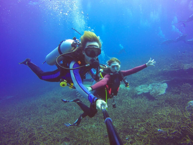 Underwater scuba diving selfie shot with selfie stick. Deep blue sea. Wide angle shot.